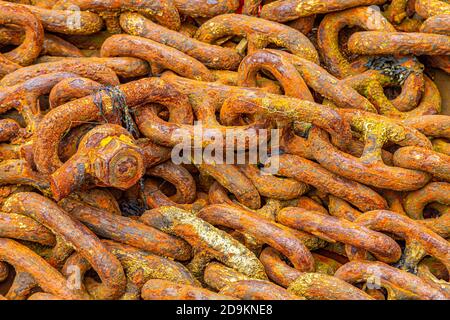 Old rusty anchor chain on a rock. Stock Photo