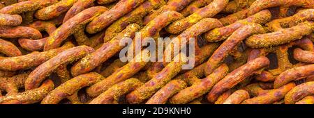 Old rusty anchor chain on a rock. Stock Photo