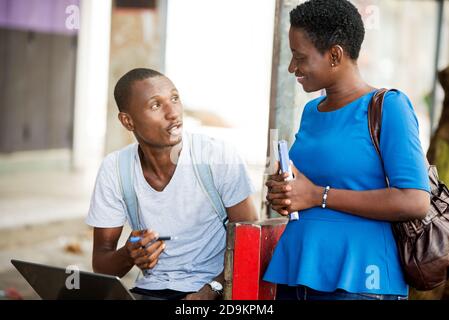 two young students woman and man study sitting in town after school Stock Photo