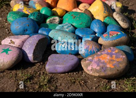 Decorated stones on the ground with 'NHS' written on the centre stone, recognition for the work done in the Covid-19 pandemic. Stock Photo