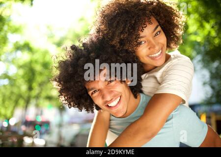 Close up portrait happy african american girl on boyfriends back Stock Photo