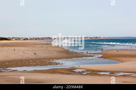 People walking along tidal flats at low tide at Ogunquit Beach in Maine, United States, USA. Stock Photo