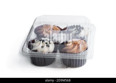 Set of  mini cupcakes in plastic container isolated on white Stock Photo