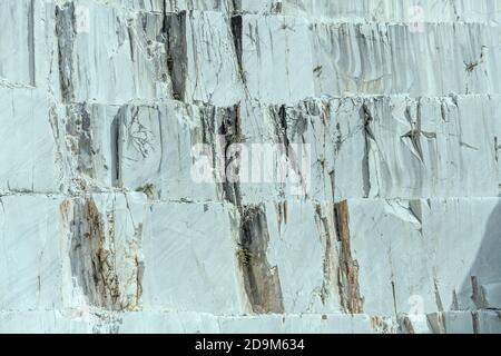 detail of veined marble on vertical surface at white marble quarry, shot in bright light near Carrara, Apuane, Tuscany, Italy Stock Photo