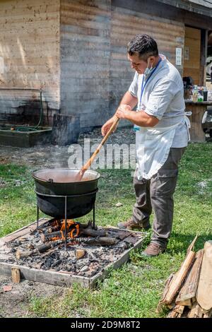 Sibiu City, Romania - 26 July 2020. an unknown person prepares a traditional Romanian food prepared at the cauldron on the open fire Stock Photo