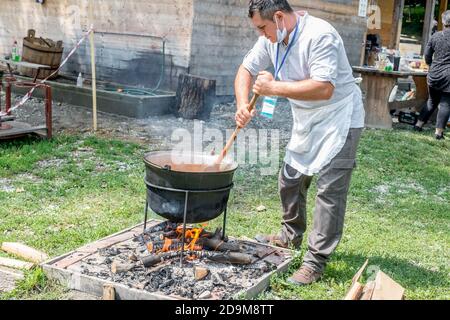 Sibiu City, Romania - 26 July 2020. an unknown person prepares a traditional Romanian food prepared at the cauldron on the open fire Stock Photo