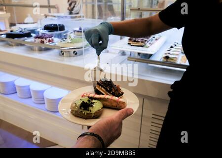 Belek, Turkey - October 2020: Serving cake at a restaurant in an all-inclusive resort in Antalya. Healthy safety measures during coronavirus outbreak. Stock Photo