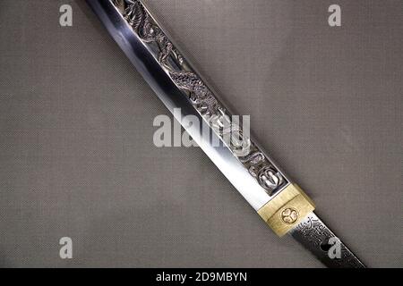 A closed up view of a small Tachi sword with engravings from Momyama period display in Japanese Sword Museum.Tokyo.Japan Stock Photo