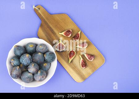 Whole and cut figs on a blue background. Copy space. Stock Photo