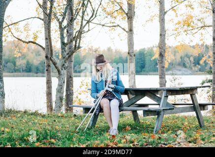 injured woman with her crutches getting fresh air after surgery Stock Photo