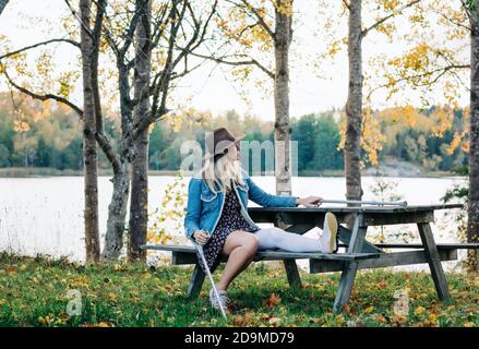 injured woman outside with crutches getting fresh air after surgery Stock Photo