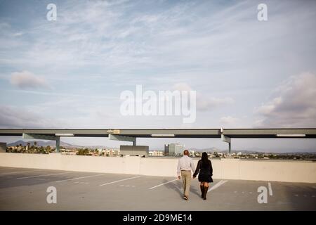 Multiracial Late Forties Couple Walking on Rooftop in San Diego Stock Photo