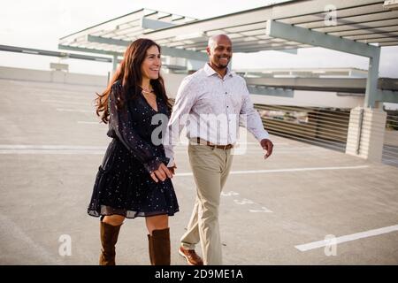 Multiracial Late Forties Couple Walking on Rooftop in San Diego Stock Photo