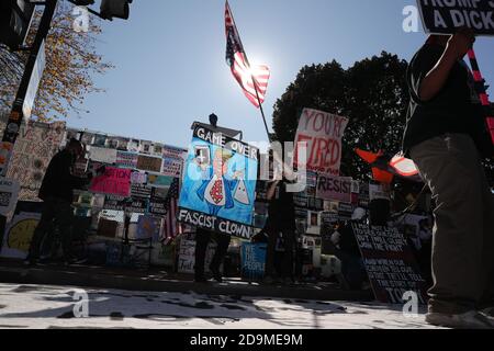 Washington, USA. 06th Nov, 2020. Protesters against President Donald Trump wave flags and sit in front of signs saying 'Game over Fascist Clown' 'You're fired' 'Resist' 'Remove Trump' gather at Black Lives Matter Plaza in front of the White House as they wait for the result of the US Presidential elections between President Donald Trump and former Vice President Joe Biden on November 6, 2020 in Washington. (Photo by Oliver Contreras/SIPA USA) Credit: Sipa USA/Alamy Live News Stock Photo