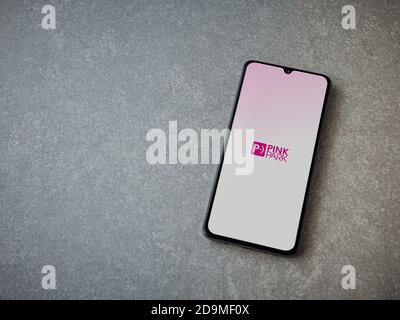 Lod, Israel - July 8, 2020: Pink Park app launch screen with logo on the display of a black mobile smartphone on ceramic stone background. Top view fl Stock Photo