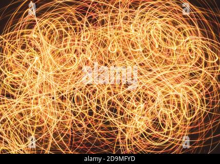 orange red and yellow laser lights intertwining on black background Stock Photo