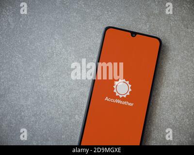 Lod, Israel - July 8, 2020: AccuWeather app launch screen with logo on the display of a black mobile smartphone on ceramic stone background. Top view Stock Photo