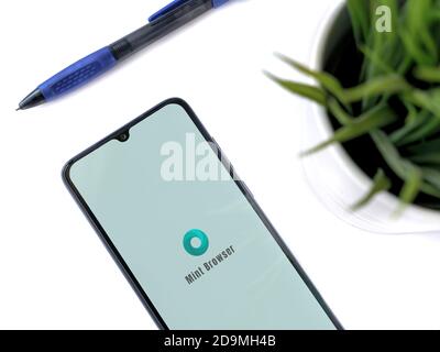 Lod, Israel - July 8, 2020: Modern minimalist office workspace with black mobile smartphone with Mint Browser app launch screen with logo on white bac Stock Photo