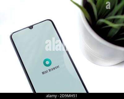 Lod, Israel - July 8, 2020: Modern minimalist office workspace with black mobile smartphone with Mint Browser app launch screen with logo on white bac Stock Photo