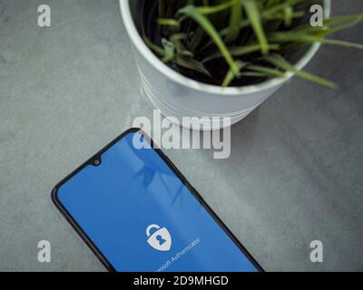Lod, Israel - July 8, 2020: Modern minimalist office workspace with black mobile smartphone with Microsoft Authenticator app launch screen with logo o Stock Photo