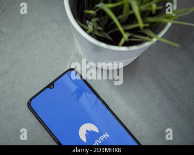 Lod, Israel - July 8, 2020: Modern minimalist office workspace with black mobile smartphone with NordVPN app launch screen with logo on marble backgro Stock Photo