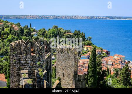 Piran, Istria, Slovenia - city overview, view over the city wall and the roofs of the port city on the Mediterranean Sea, tourists photograph themselves on the historic city wall.