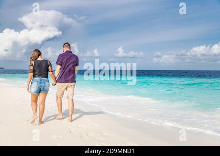 Couple walking on beach. Luxury summer honeymoon vacation destination. Tropical nature beach scenery Stock Photo