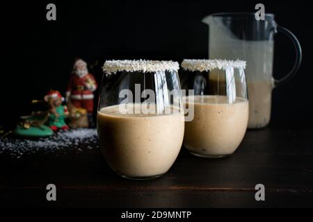Glasses of Coquito Rimmed with Coconut Flakes: Traditional Puerto Rican Christmas drink with coconut, rum, and cinnamon Stock Photo