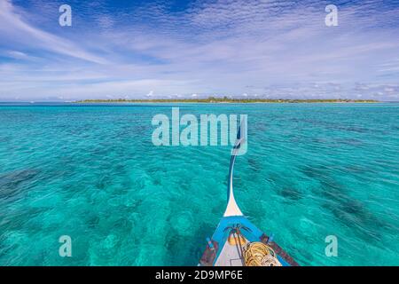 Traditional Maldivian boat Dhoni with amazing tropical island background view. Nature paradise beach, open sea view, seascape in Maldives, luxury Stock Photo