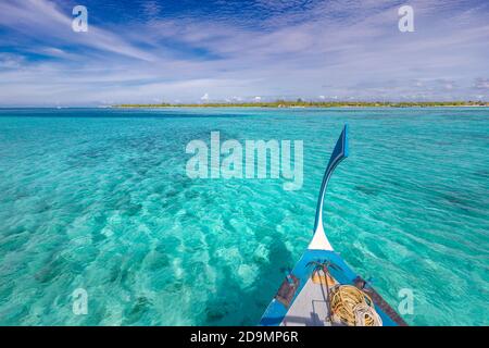 Traditional Maldivian boat Dhoni with amazing tropical island background view. Nature paradise beach, open sea view, seascape in Maldives, luxury Stock Photo