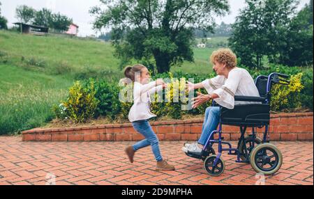 Granddaughter running to greet her grandmother Stock Photo