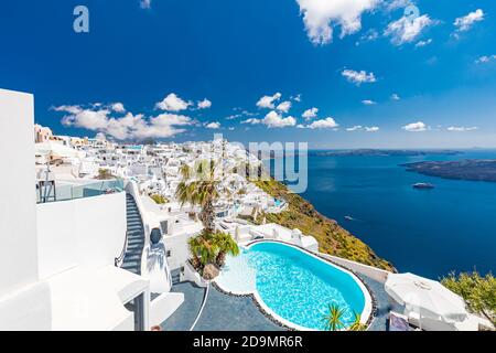 Beautiful white caldera view of Santorini in Greece. Luxury hotel resort pool over white architecture and sea view, blue sky. Summer travel vacation Stock Photo