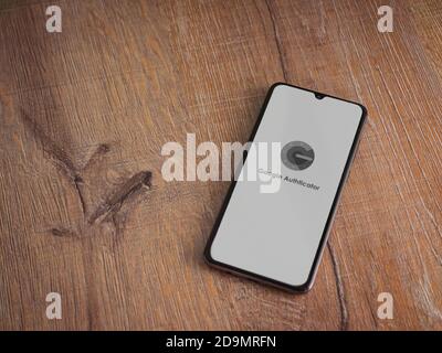 Lod, Israel - July 8, 2020: Google Authenticator app launch screen with logo on the display of a black mobile smartphone on wooden background. Top vie Stock Photo