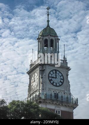 Buenos Aires, Argentina- December 19, 2008: Upper section of British naval clock tower against blue cloudscape with green folliage. Stock Photo