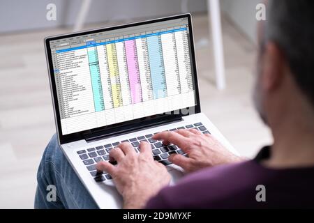 Elder Man Using Spreadsheet Data On Laptop Computer Stock Photo