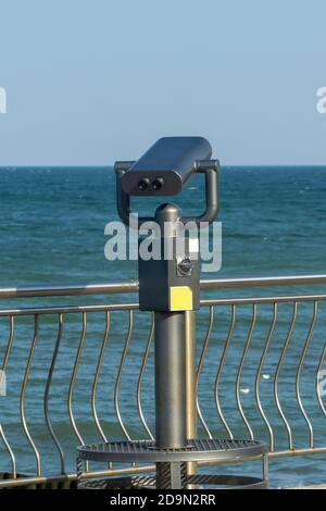 Stationary public beach binoculars on seashore. Coin-operated binocular viewer for tourists. Stock Photo