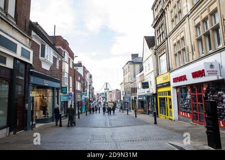 Windsor, UK. 6th November, 2020. Very few people are visible in the usually bustling Peascod Street, the heart of the town’s shopping area, on the second day of England’s second coronavirus lockdown. Only retailers selling 'essential' goods and services are permitted to open to the public during the second lockdown and cafes, restaurants and pubs must remain closed unless they are providing food and drink for takeaway before 10pm, click-and-collect, drive-through or delivery. Credit: Mark Kerrison/Alamy Live News Stock Photo