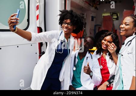 Group of african paramedic ambulance emergency crew doctors making selfie on phone.