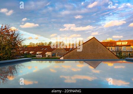 Colorful clouds at sunset are reflected in a skylight window Stock Photo