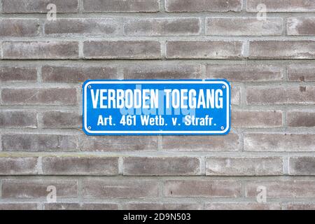 Sign attached to a wall with the Dutch text 'prohibited access for unauthorized persons, article 461 penal code'. Official Dutch 'No Entry' sign. Stock Photo