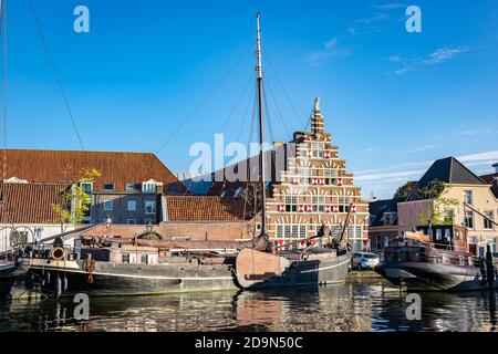 Scenic view of traditional dutch canal house and boats in Oude Rijn river.  In this neigbourhood the famous dutch painter Rembrandt was born. Stock Photo