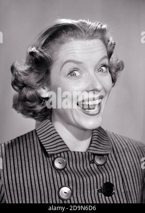1950s PORTRAIT OF EXCITED HAPPY WOMAN WEARING STRIPED BUTTONED TOP WIDE SMILE BUG-EYES FLIP HAIRSTYLE LOOKING AT CAMERA - g1884 DEB001 HARS EXPRESSIONS B&W WIDE EYE CONTACT SUCCESS BUG-EYED HAPPINESS HEAD AND SHOULDERS CHEERFUL DISCOVERY EXCITEMENT HAIRSTYLE PRIDE SMILES JOYFUL STYLISH DEB001 WIDE-EYED BUTTONED MID-ADULT MID-ADULT WOMAN BLACK AND WHITE CAUCASIAN ETHNICITY OLD FASHIONED Stock Photo
