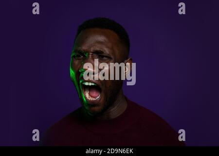 Black man shouting with mouth wide open. Portrait. Isolated background. Head shot. Stock Photo