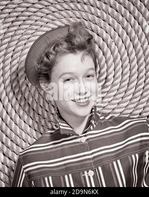 1960s SMILING YOUNG WOMAN SAILOR WEARING STITCHED CAP STRIPED SHIRT LOOKING AT CAMERA LEANING ON SPIRAL OF COILED NAUTICAL ROPE - g5074 HAR001 HARS OLD FASHION 1 JUVENILE FACIAL SAILING YOUNG ADULT PLEASED JOY LIFESTYLE SAILOR FEMALES STRIPED STUDIO SHOT HEALTHINESS COPY SPACE LADIES PERSONS TEENAGE GIRL NAUTICAL EXPRESSIONS B&W EYE CONTACT THEME HAPPINESS CHEERFUL RECREATION OF ON SMILES SPIRAL BOATING COILED JOYFUL TEENAGED PLEASANT FRESH-FACED JUVENILES STITCHED YOUNG ADULT WOMAN YOUNGSTER YOUTHFUL BLACK AND WHITE CAUCASIAN ETHNICITY HAR001 OLD FASHIONED Stock Photo