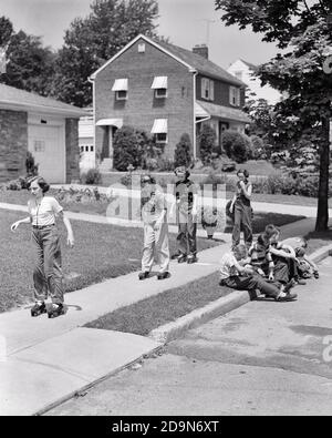 1950s GROUP OF EIGHT BOYS AND GIRLS PRETEENS AND TEENS ROLLER SKATING ON SUBURBAN STREET SIDEWALK  - j4993 HAR001 HARS ATHLETE LIFESTYLE FEMALES HOUSES HEALTHINESS HOME LIFE COPY SPACE FRIENDSHIP FULL-LENGTH HALF-LENGTH PHYSICAL FITNESS PERSONS INSPIRATION RESIDENTIAL MALES TEENAGE GIRL TEENAGE BOY ATHLETIC BUILDINGS CONFIDENCE B&W SUMMERTIME NEIGHBORS ACTIVITY 8 HAPPINESS PHYSICAL WELLNESS NEIGHBORHOOD HIGH ANGLE ADVENTURE LEISURE STRENGTH EXTERIOR RECREATION HOMES FLEXIBILITY FRIENDLY MUSCLES RESIDENCE TEENAGED COOPERATION EIGHT GROWTH JUVENILES PRE-TEEN PRE-TEEN BOY PRE-TEEN GIRL Stock Photo