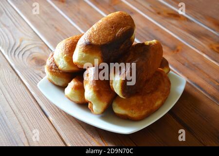 Several home baked pies on the white plate on the wooden background Stock Photo