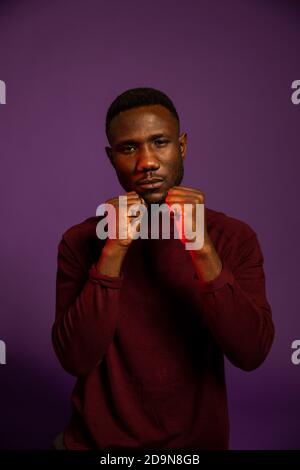 African man in boxing guard with fist clenched looking at camera. Medium shot. Isolated background. Stock Photo