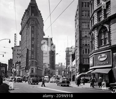 1950s THE ENGLISH-AMERICAN OR FLATIRON BUILDING CARS PEDESTRIANS AT BROAD AND PEACHTREE STREET INTERSECTION ATLANTA GEORGIA USA - q75036 CPC001 HARS PROPERTY MOTOR VEHICLE AND AUTOS EXTERIOR LOW ANGLE BROAD AT THE REAL ESTATE STRUCTURES AUTOMOBILES VEHICLES EDIFICE FLATIRON OR BUSES STREET SCENE TRANSIT 1897 BLACK AND WHITE GA MOTOR VEHICLES OLD FASHIONED Stock Photo