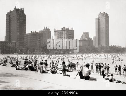 1930s SUNBATHERS ON BEACH LAKE MICHIGAN LAKE SHORE DRIVE SKYSCRAPERS OF MICHIGAN AVENUE IN BACKGROUND CHICAGO ILLINOIS USA - r6420 HAR001 HARS LADIES PERSONS SCENIC UNITED STATES OF AMERICA MALES BUILDINGS MICHIGAN B&W SUMMERTIME SHORE LEISURE PROPERTY RECREATION REAL ESTATE STRUCTURES CITIES ESCAPE EDIFICE PANORAMIC SUNBATHERS TOGETHERNESS BLACK AND WHITE HAR001 LAKE MICHIGAN MIDWEST MIDWESTERN OLD FASHIONED SKYSCRAPERS WOMEN Stock Photo