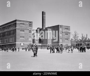 1930s URBAN BRICK PUBLIC ELEMENTARY SCHOOL BUILDING WITH BOYS AND GIRLS PLAYING OUTSIDE AT RECESS ON HARD SURFACE PLAYGROUND - s8993 HAR001 HARS COATS COPY SPACE FULL-LENGTH MALES BUILDINGS B&W SCHOOLS GRADE HAPPINESS NEIGHBORHOOD PROPERTY AND EXCITEMENT EXTERIOR RECESS RECREATION AT ON PRIMARY REAL ESTATE STRUCTURES EDIFICE COOPERATION GRADE SCHOOL JUVENILES PRE-TEEN PRE-TEEN BOY PRE-TEEN GIRL TOGETHERNESS BLACK AND WHITE HAR001 OLD FASHIONED Stock Photo